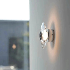Inspira Lifestyles | Onda Crystal Wall Light with round optical crystal disc and chrome center, mounted as a modern LED wall or ceiling sconce.