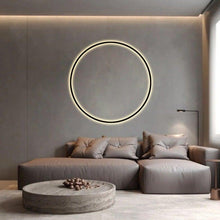 Load image into Gallery viewer, INSPIRA LIFESTYLES – Minimalist Metal Ring Light, a modern circular LED wall light with sleek sculptural design. This versatile wall sconce doubles as accent lighting and wall art, perfect as a bedroom light above a headboard, a living room statement piece, or a minimalist hallway fixture. Contemporary ring light crafted in metal with soft LED illumination, ideal for modern interiors seeking sculptural lighting, circle lights, or functional yet artistic wall sconces.

