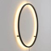 Load image into Gallery viewer, INSPIRA LIFESTYLES – Minimalist Metal Ring Light, a modern circular LED wall light with sleek sculptural design. This versatile wall sconce doubles as accent lighting and wall art, perfect as a bedroom light above a headboard, a living room statement piece, or a minimalist hallway fixture. Contemporary ring light crafted in metal with soft LED illumination, ideal for modern interiors seeking sculptural lighting, circle lights, or functional yet artistic wall sconces.
