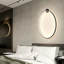 Load image into Gallery viewer, INSPIRA LIFESTYLES – Minimalist Metal Ring Light, a modern circular LED wall light with sleek sculptural design. This versatile wall sconce doubles as accent lighting and wall art, perfect as a bedroom light above a headboard, a living room statement piece, or a minimalist hallway fixture. Contemporary ring light crafted in metal with soft LED illumination, ideal for modern interiors seeking sculptural lighting, circle lights, or functional yet artistic wall sconces.
