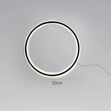 Load image into Gallery viewer, INSPIRA LIFESTYLES – Minimalist Metal Ring Light, a modern circular LED wall light with sleek sculptural design. This versatile wall sconce doubles as accent lighting and wall art, perfect as a bedroom light above a headboard, a living room statement piece, or a minimalist hallway fixture. Contemporary ring light crafted in metal with soft LED illumination, ideal for modern interiors seeking sculptural lighting, circle lights, or functional yet artistic wall sconces.
