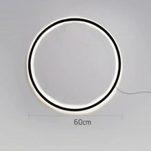 Load image into Gallery viewer, INSPIRA LIFESTYLES – Minimalist Metal Ring Light, a modern circular LED wall light with sleek sculptural design. This versatile wall sconce doubles as accent lighting and wall art, perfect as a bedroom light above a headboard, a living room statement piece, or a minimalist hallway fixture. Contemporary ring light crafted in metal with soft LED illumination, ideal for modern interiors seeking sculptural lighting, circle lights, or functional yet artistic wall sconces.
