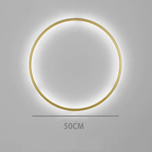 Load image into Gallery viewer, INSPIRA LIFESTYLES – Minimalist Metal Ring Light, a modern circular LED wall light with sleek sculptural design. This versatile wall sconce doubles as accent lighting and wall art, perfect as a bedroom light above a headboard, a living room statement piece, or a minimalist hallway fixture. Contemporary ring light crafted in metal with soft LED illumination, ideal for modern interiors seeking sculptural lighting, circle lights, or functional yet artistic wall sconces.

