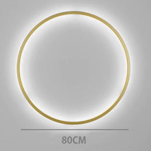 Load image into Gallery viewer, INSPIRA LIFESTYLES – Minimalist Metal Ring Light, a modern circular LED wall light with sleek sculptural design. This versatile wall sconce doubles as accent lighting and wall art, perfect as a bedroom light above a headboard, a living room statement piece, or a minimalist hallway fixture. Contemporary ring light crafted in metal with soft LED illumination, ideal for modern interiors seeking sculptural lighting, circle lights, or functional yet artistic wall sconces.
