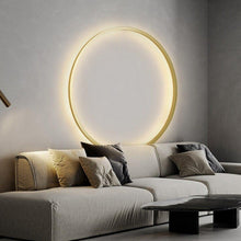 Load image into Gallery viewer, INSPIRA LIFESTYLES – Minimalist Metal Ring Light, a modern circular LED wall light with sleek sculptural design. This versatile wall sconce doubles as accent lighting and wall art, perfect as a bedroom light above a headboard, a living room statement piece, or a minimalist hallway fixture. Contemporary ring light crafted in metal with soft LED illumination, ideal for modern interiors seeking sculptural lighting, circle lights, or functional yet artistic wall sconces.
