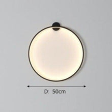 Load image into Gallery viewer, INSPIRA LIFESTYLES – Minimalist Metal Ring Light, a modern circular LED wall light with sleek sculptural design. This versatile wall sconce doubles as accent lighting and wall art, perfect as a bedroom light above a headboard, a living room statement piece, or a minimalist hallway fixture. Contemporary ring light crafted in metal with soft LED illumination, ideal for modern interiors seeking sculptural lighting, circle lights, or functional yet artistic wall sconces.
